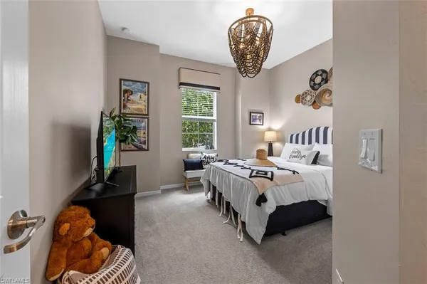 a bedroom with a bed and a chandelier