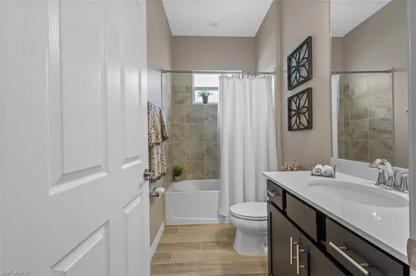 a bathroom with a sink a toilet a mirror and shower