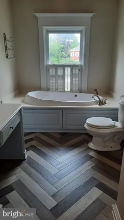 a bathroom with a sink a toilet and a window