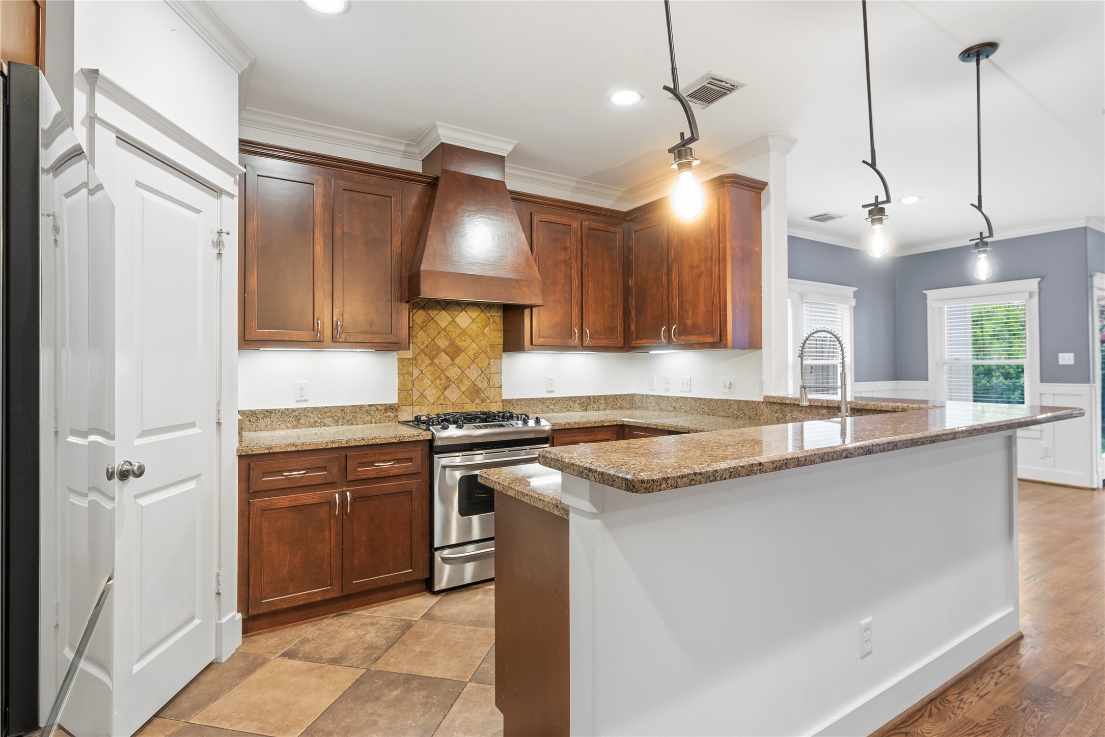 1505 Prince Street Houston, TX 77008 - Photo 12 of 39 The kitchen showcases a two-tiered counter, timeless granite, and rich cabinetry, with ample storage, a walk-in pantry, and a handsome wood hood to complete the look.