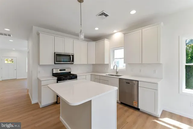 a kitchen with a sink a stove a microwave and cabinets
