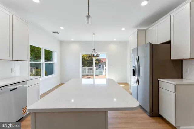a kitchen with stainless steel appliances a refrigerator and a window