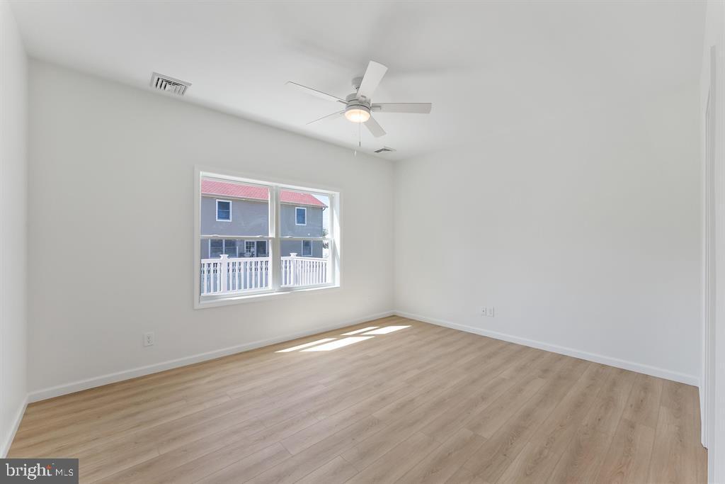 206 Frances Avenue, Unit A Villas, NJ 08251 - Photo 19 of 48 an empty room with wooden floor ceiling fan and windows