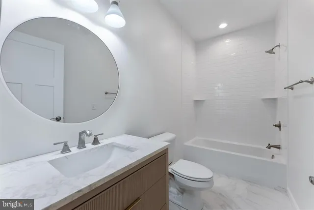 a bathroom with a sink toilet vanity and shower
