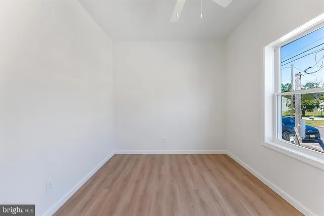 a view of a room that has wooden floor and a window