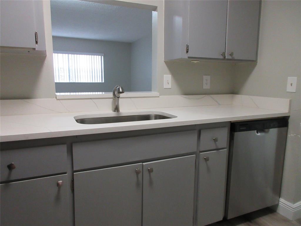 4240 Woodside Drive, Unit 4 Coral Springs, FL 33065 - Photo 7 of 13 a kitchen with a sink and cabinets