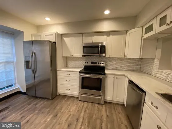 a kitchen with granite countertop a refrigerator stove and sink