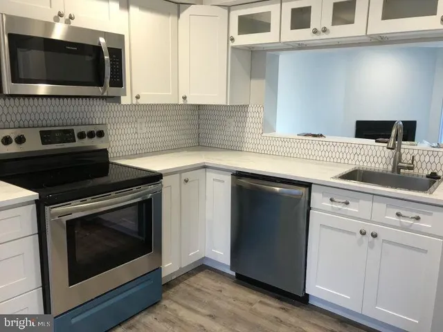a kitchen with stainless steel appliances a stove microwave and sink