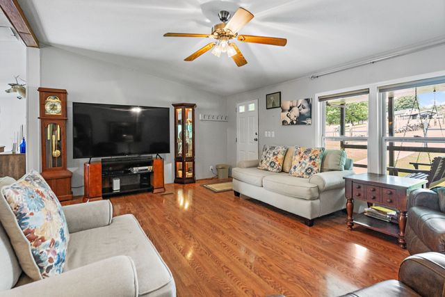 a kitchen with granite countertop a table chairs a sink dishwasher refrigerator and cabinets