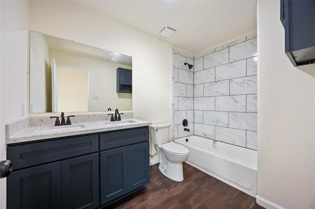 a bathroom with a bathtub shower sink mirror and toilet
