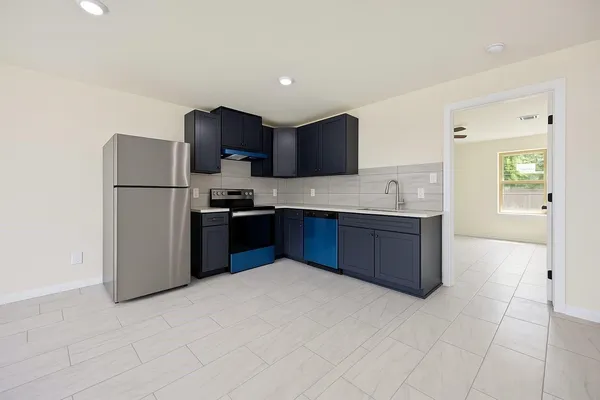 a kitchen with stainless steel appliances granite countertop a refrigerator and a stove