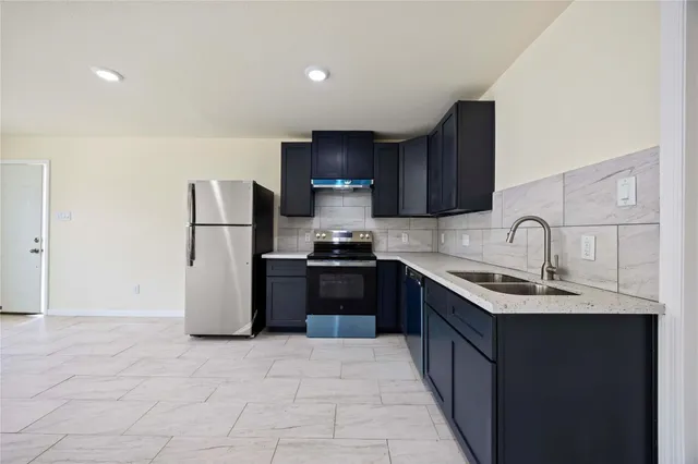 a kitchen with a sink cabinets and refrigerator