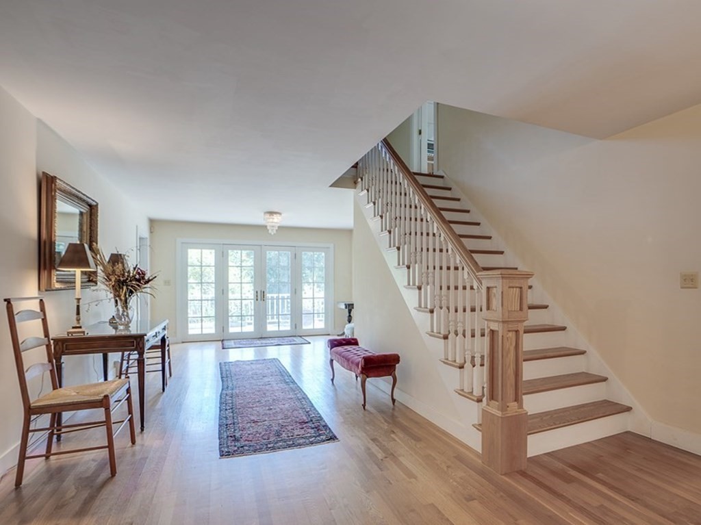 163 Still River Road Harvard, MA 01451 - Photo 11 of 42 a living room with stairs and a wooden floor