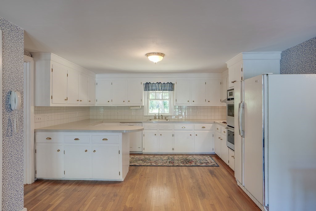 163 Still River Road Harvard, MA 01451 - Photo 20 of 42 a kitchen with granite countertop white cabinets and refrigerator