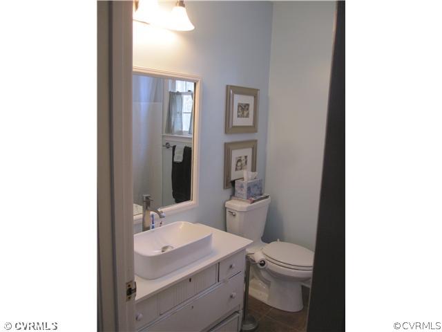 9279 Drawbridge Road Mechanicsville, VA 23116 - Photo 11 of 14 a bathroom with a granite countertop toilet a sink and a mirror