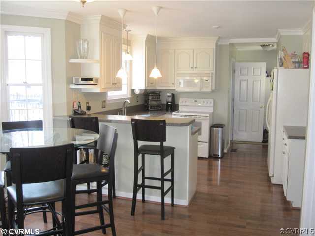 9279 Drawbridge Road Mechanicsville, VA 23116 - Photo 4 of 14 a kitchen with stainless steel appliances a dining table chairs and a refrigerator