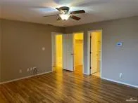 a view of an empty room with window and wooden floor