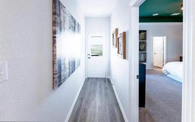 a view of a hallway with wooden floor and staircase