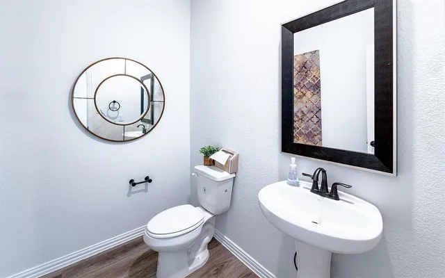 a bathroom with a toilet sink and mirror