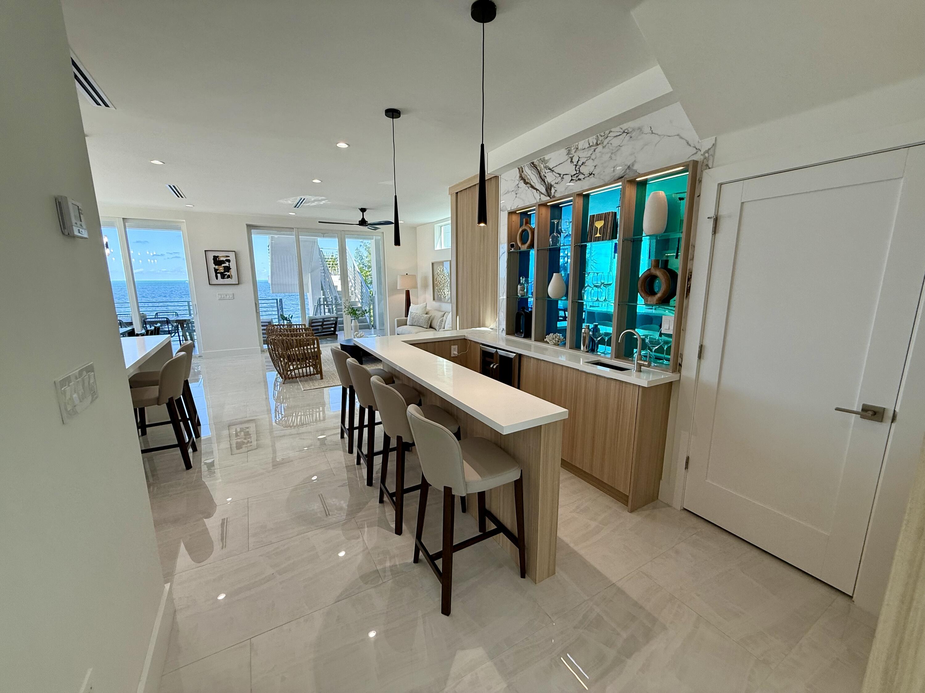 990 41st Street, Unit 9 Marathon, FL 33050 - Photo 11 of 52 a dining hall with stainless steel appliances kitchen island granite countertop a table chairs and a rug