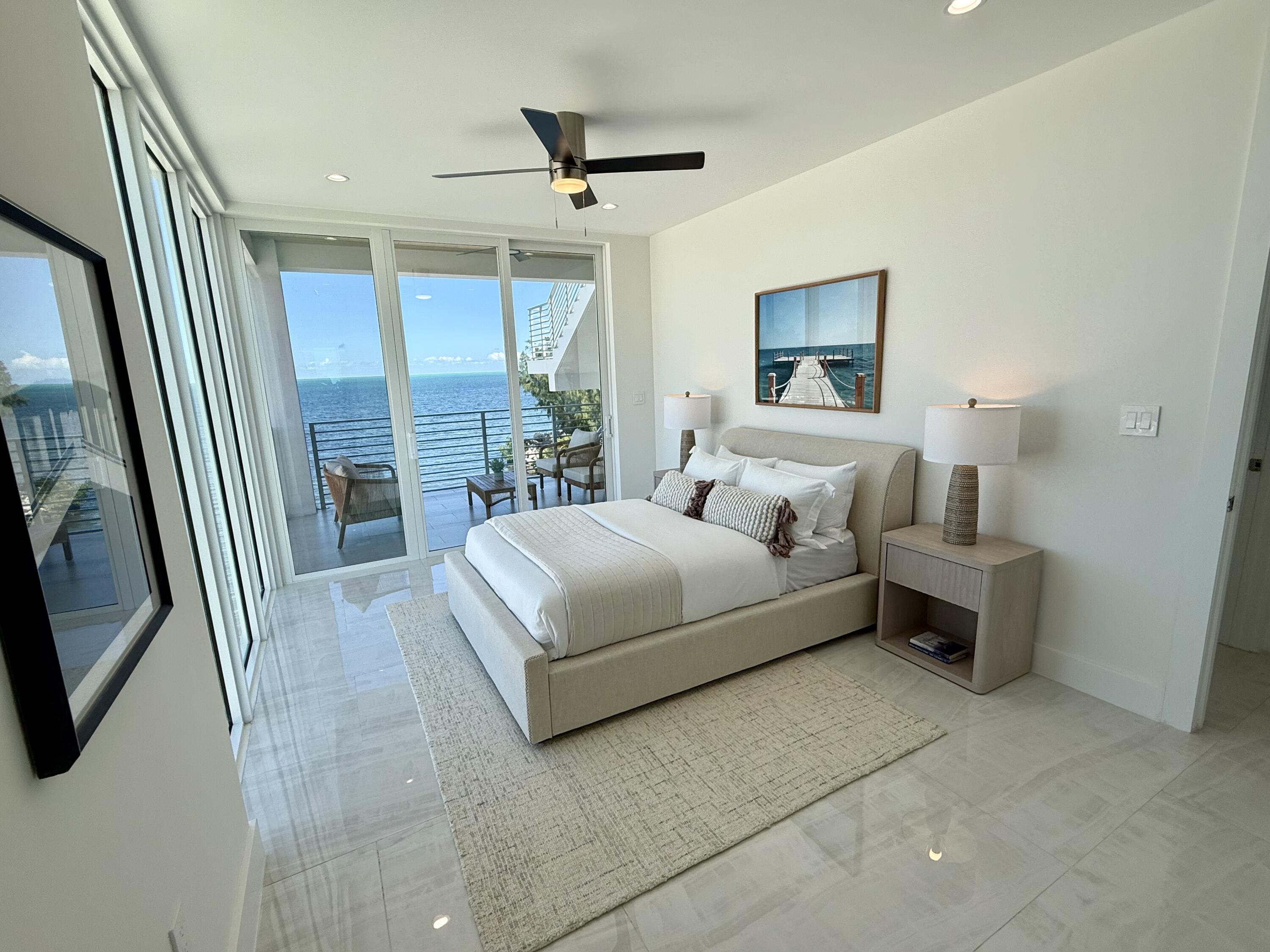 990 41st Street, Unit 9 Marathon, FL 33050 - Photo 28 of 52 a bedroom with a bed a large window and wooden floor