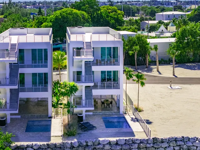 a view of multiple houses with a yard and plants