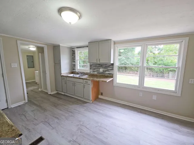 a kitchen with stainless steel appliances granite countertop a stove a sink and a refrigerator with wooden floors