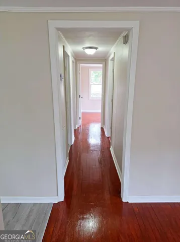 a view of a hallway with wooden floor
