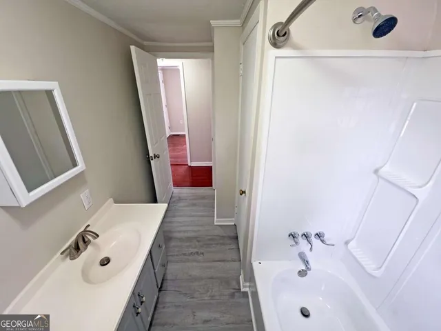 a bathroom with a bathtub sink and mirror