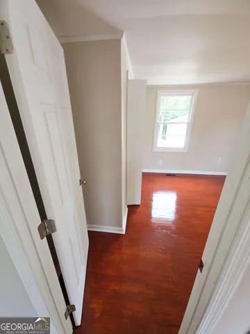 a view of a hallway with window and wooden floor