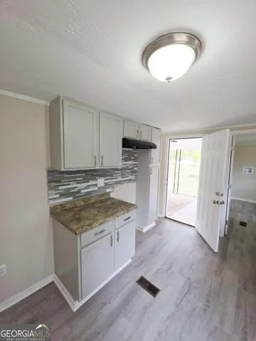 a kitchen with granite countertop a stove and a sink