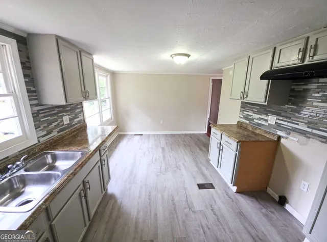 a kitchen with wooden floors and a sink