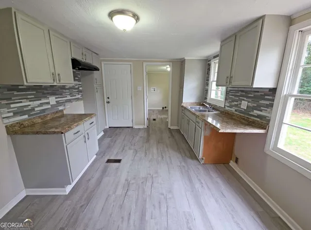 a kitchen with granite countertop wooden floors and white appliances