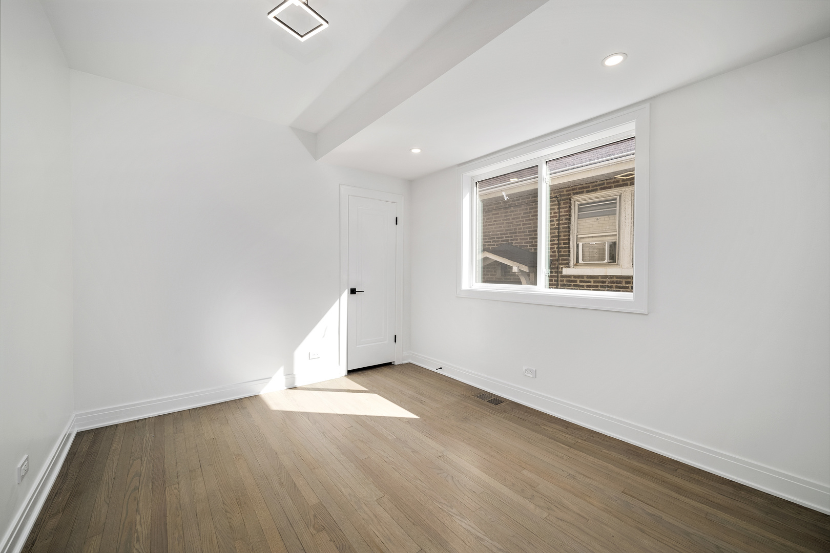 6747 Riverside Drive Berwyn, IL 60402 - Photo 17 of 32 an empty room with wooden floor and windows