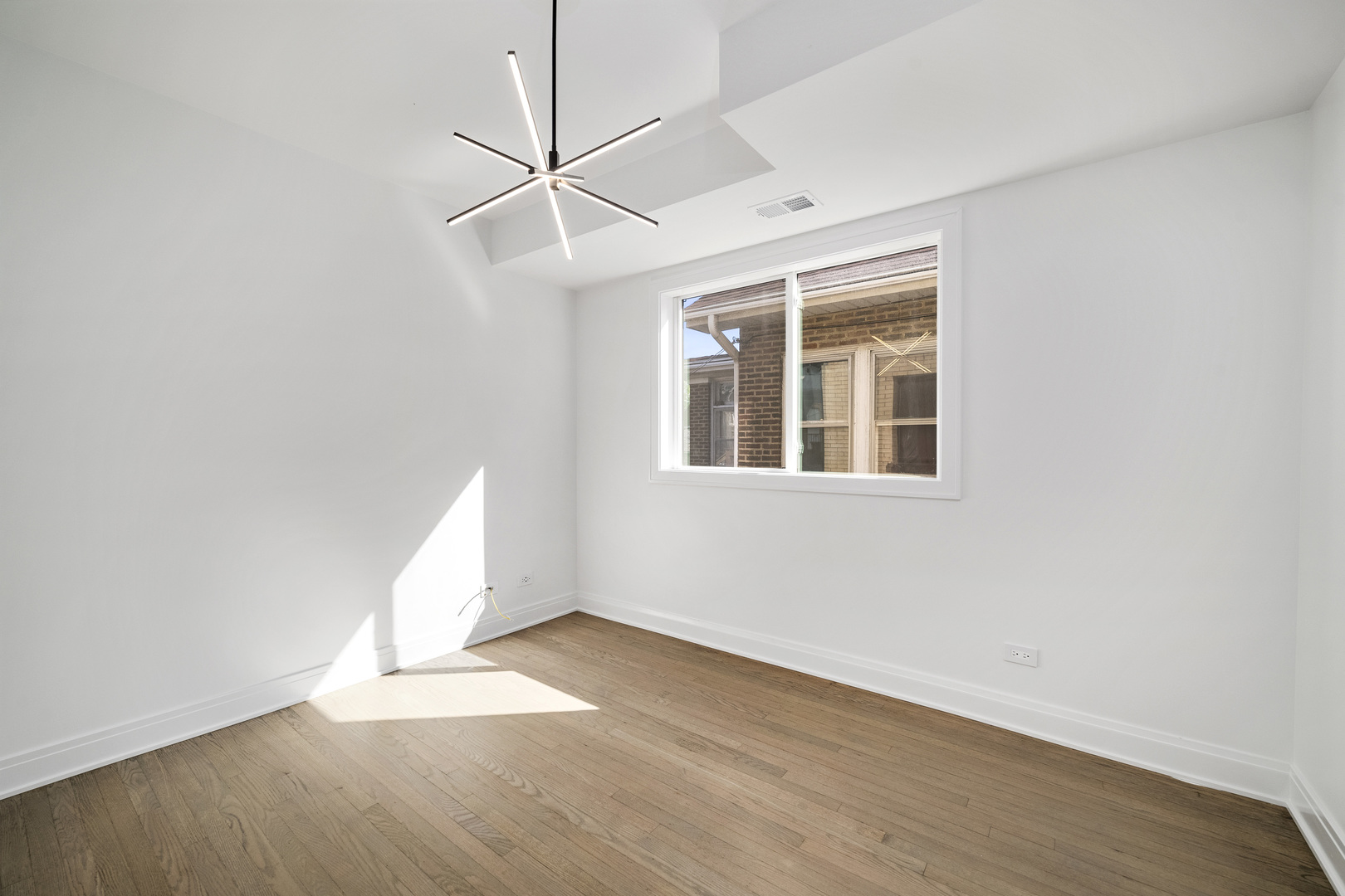 6747 Riverside Drive Berwyn, IL 60402 - Photo 18 of 32 an empty room with wooden floor and windows