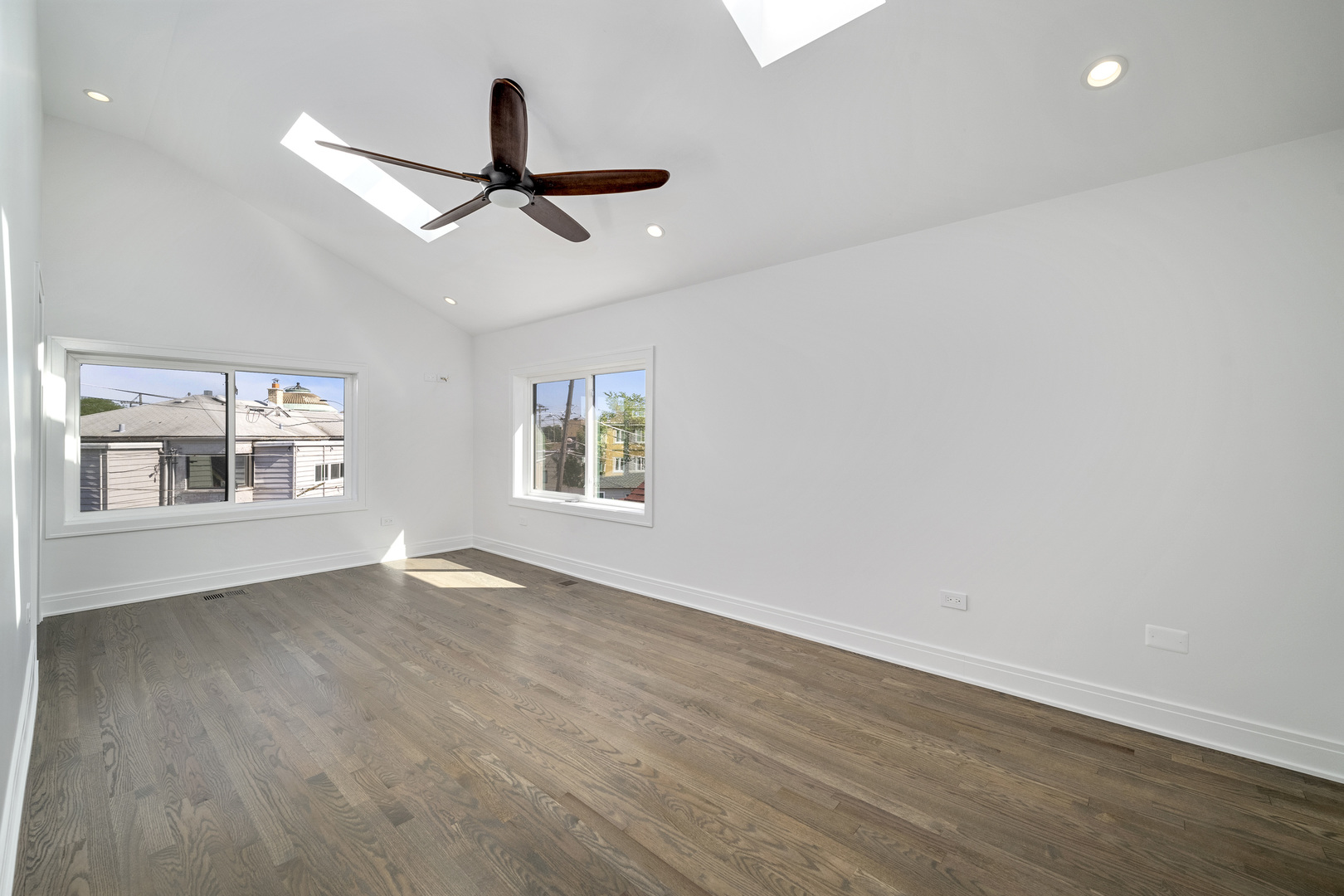 6747 Riverside Drive Berwyn, IL 60402 - Photo 20 of 32 an empty room with wooden floor ceiling fan and windows