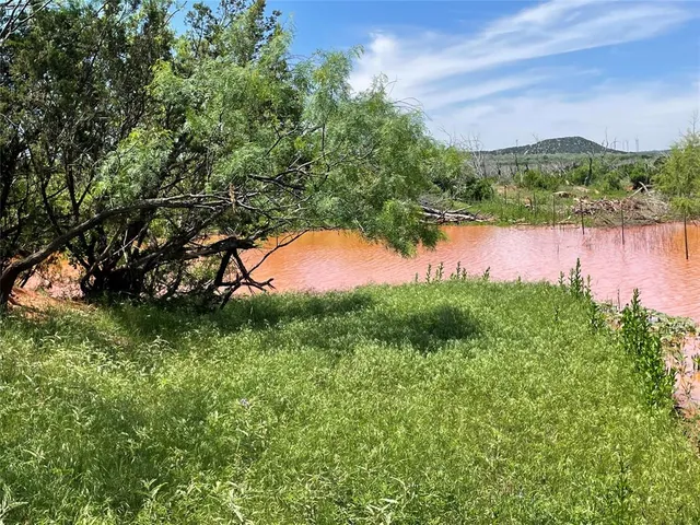 a view of a lake and green valley