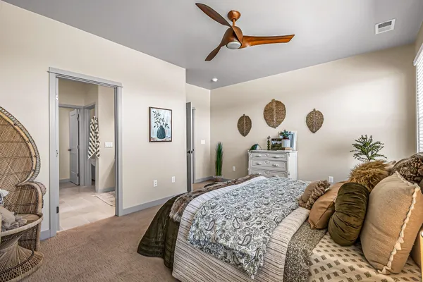 a bedroom with a large bed and a chandelier