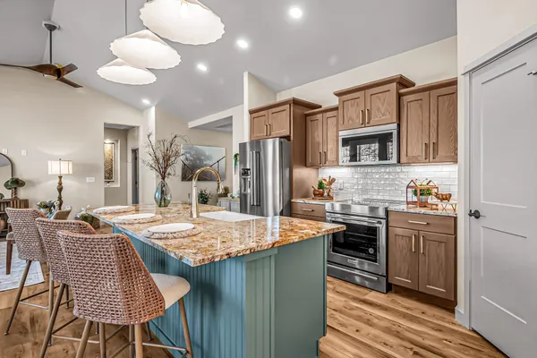 a kitchen with stainless steel appliances granite countertop a sink refrigerator and cabinets