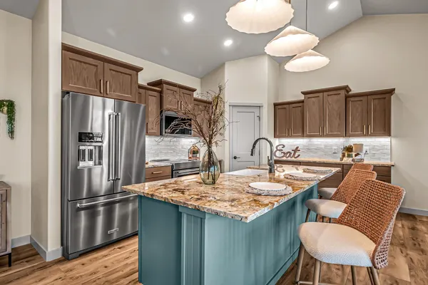 a kitchen with stainless steel appliances granite countertop a sink stove and refrigerator