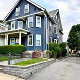 a front view of a house with a garden