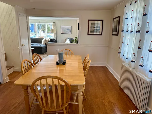 a dining room with furniture window and wooden floor