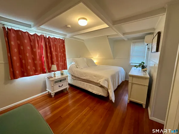 a bedroom with a bed and wooden floor