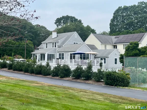 a front view of a house with a yard and potted plants