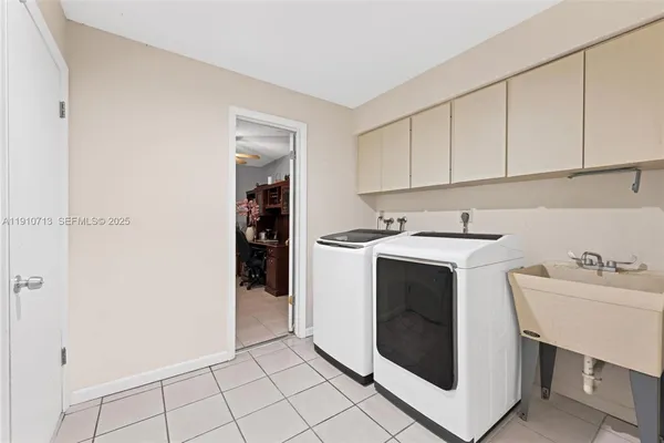 a utility room with sink dryer and washer