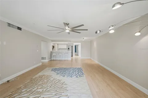 a view of a livingroom with a ceiling fan & hardwood floor