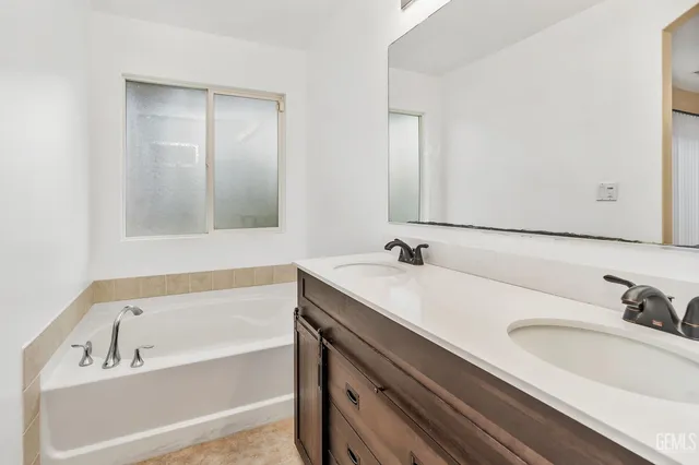 a bathroom with a tub sink and mirror