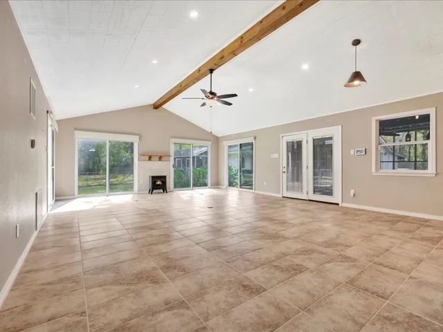a view of an empty room with a window and fireplace