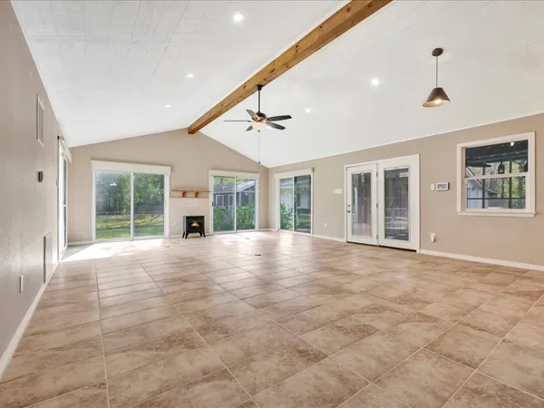 a view of an empty room with a window and fireplace