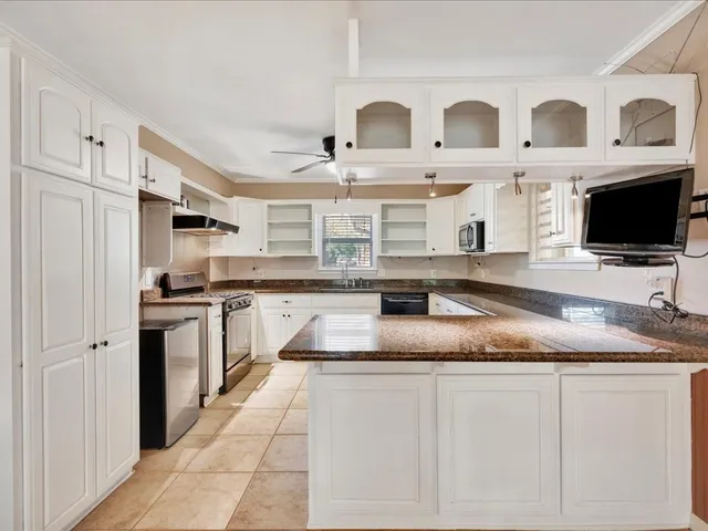 a kitchen with stainless steel appliances granite countertop a sink and a stove